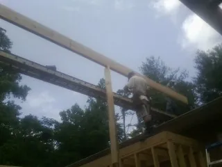 Carpenter setting a ridge beam over a new addition frame — Ice Dam Removal by Roofing Brothers in Cumberland Gap