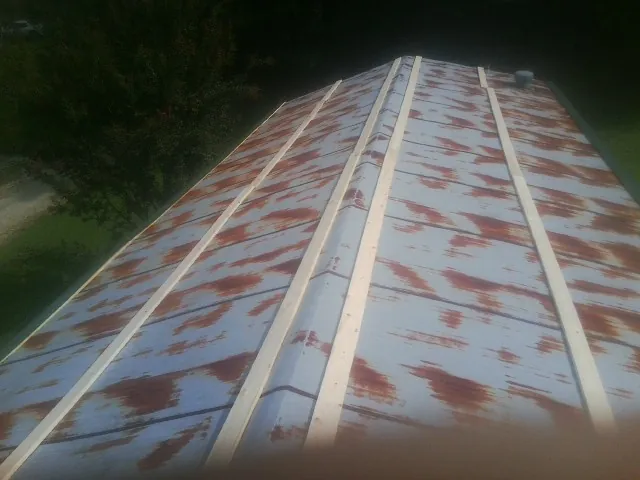 Rusted metal roof panels with new wood purlins before replacement — Storm Damage Roof Repair in Cumberland Gap by Roofing Brothers