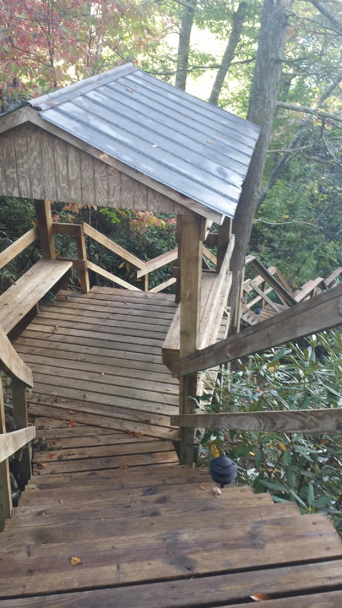 Metal roofed shelter over wooden steps on a wooded walkway — Skylight Repair & Installation work by our crew in Cumberland Gap