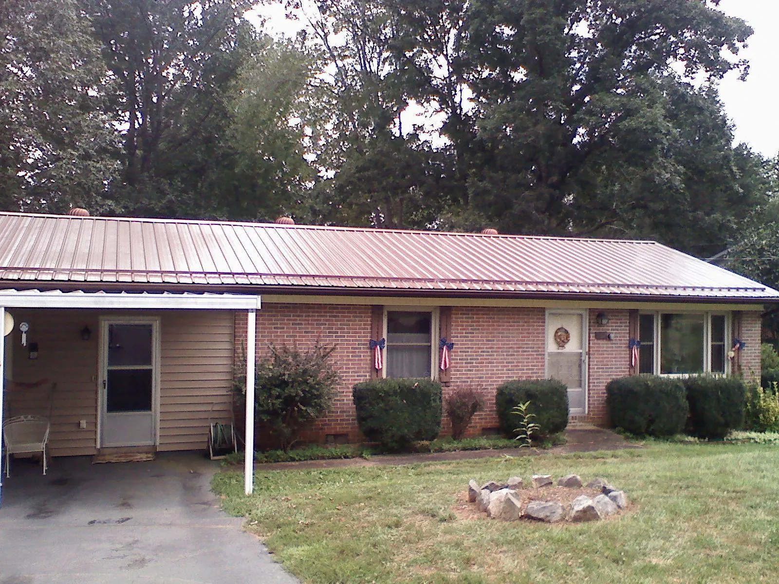Bronze metal roof and carport on a brick ranch home — Roof Repair work by our crew in Cumberland Gap